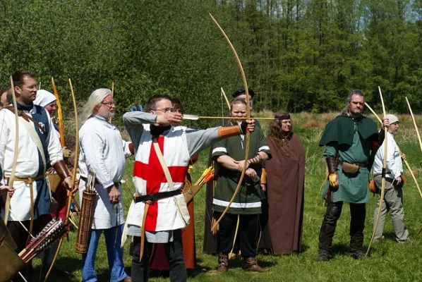 Bogenschützen in mittelalterlicher Gewandung beim Wettschiessen auf der Wiese