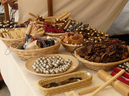 Marktstand mit handgefertigten Schellen, Glocken und Holzwaren in Weidenkörben